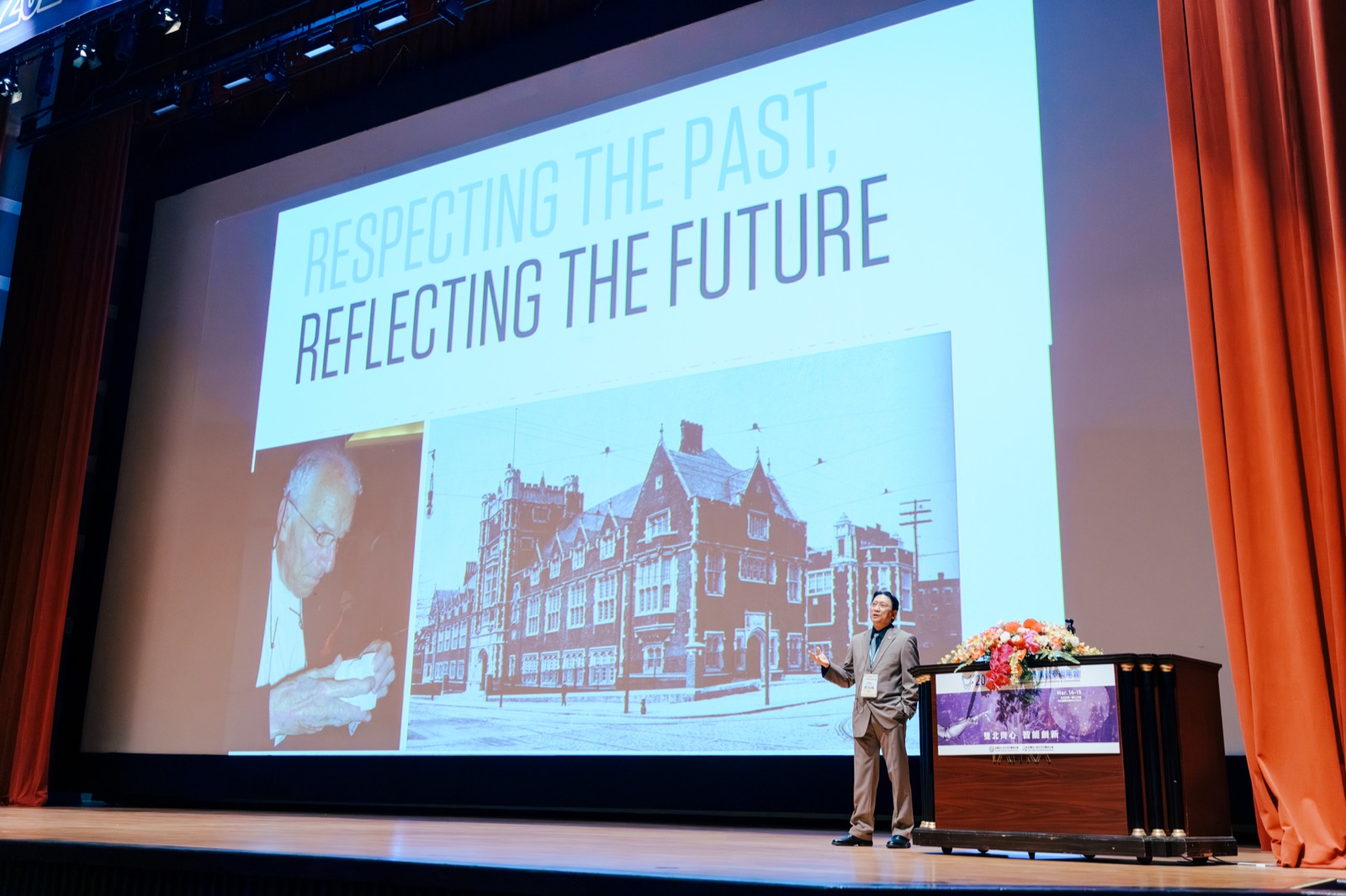 Dr. Steven Liu lecturing on stage, with a slide showing the historic Penn Dental Medicine building